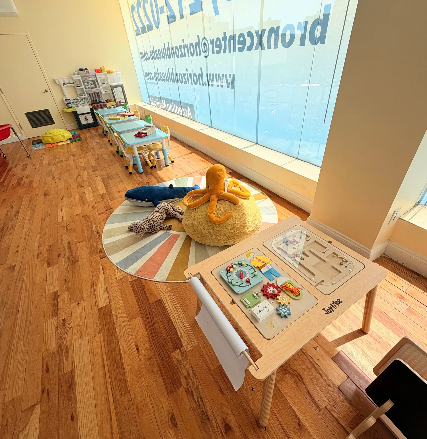 Children's play area with a toy kitchen, tables, and educational toys