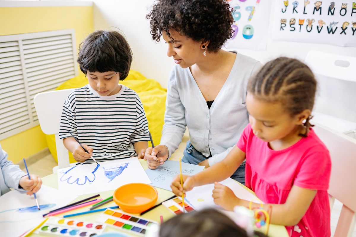 A boy and girl painting together during a creative activity